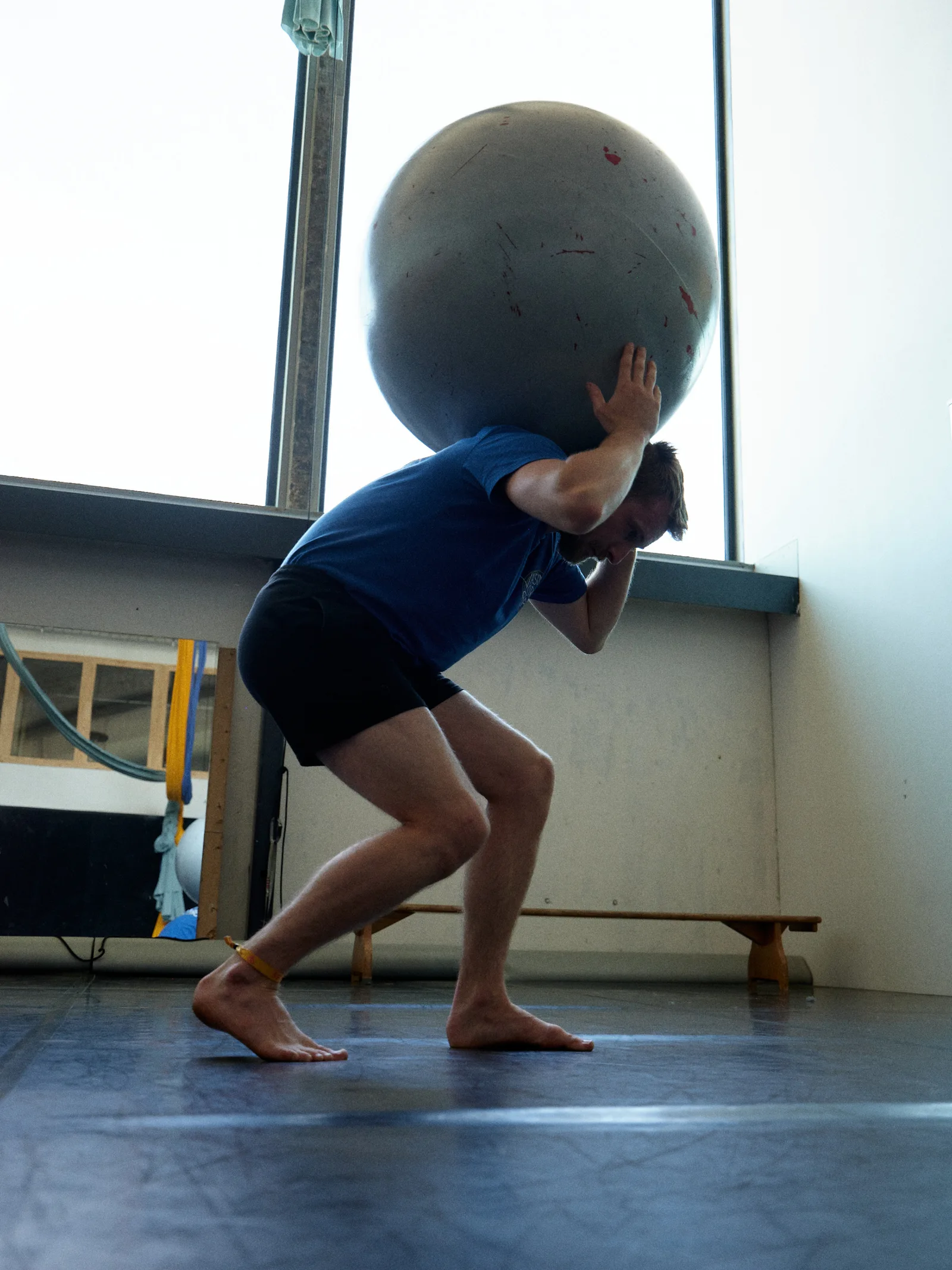 Sam balancing a large exercise ball over his shoulder