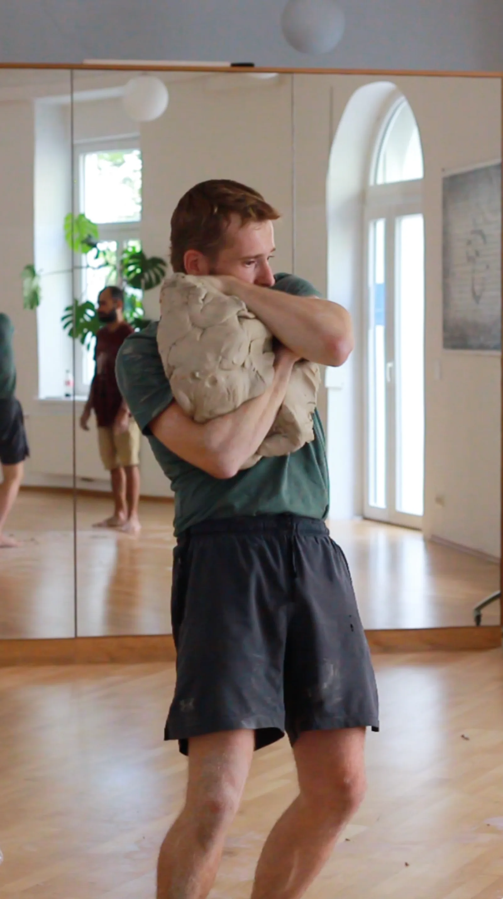 Sam holding a large ball of clay in the studio